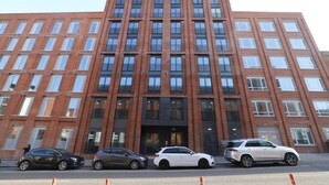 Un edificio de varios pisos con fachada simétrica, ventanas amplias y una entrada central.