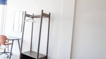 A bedroom with a bed, a desk, and a chair.