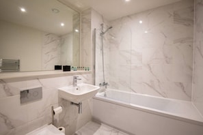 A modern bathroom with a freestanding bathtub, a sink, and a glass shower enclosure. - Sapphire Court Modern 2 Bedroom Flat 88 (Birmingham)