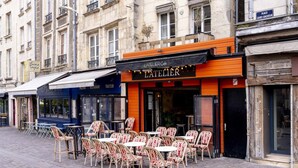 A café with outdoor seating, a sign reading 'L'ATELIER,' and a street sign indicating 'PLACE SAINT-SAUVEUR.' - The Charm of Place Saint-Sauveur (Caen)