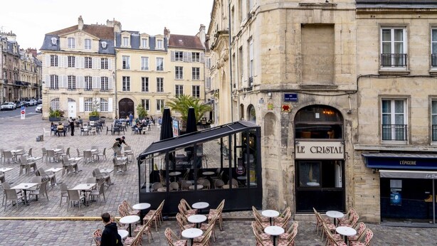 A café with outdoor seating on a cobblestone street, surrounded by historic buildings. - The Charm of Place Saint-Sauveur (Caen)