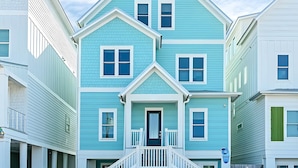 Une maison à deux étages avec un porche à l’avant et un petit escalier.