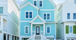 A two-story house with a front porch and a small staircase. - Ocean-view Home 7BR Retreat (Panama City Beach)
