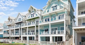 A beachfront property with multiple balconies, a wooden deck, and a clear view of the ocean. - Ocean-view Home 7BR Retreat (Panama City Beach)