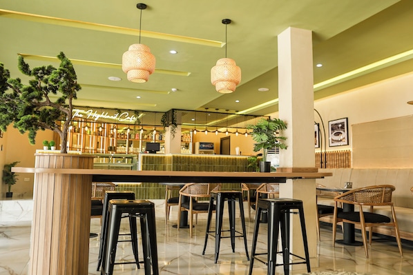 A bar area with a counter, stools, and hanging lights. - The Highland Residences (Abuja)