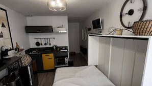 A compact room with a bed, a desk, a kitchenette, and a wardrobe. - Studio in the heart of downtown (Caen)
