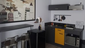 A modern kitchen with a dishwasher, microwave, and a painting of a cityscape. - Studio in the heart of downtown (Caen)