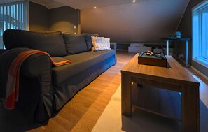 Ein modernes Wohnzimmer mit einer Couch, einem Holztisch und einem Billardtisch.