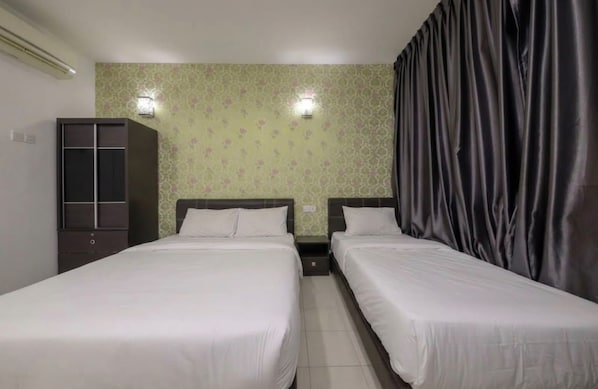 A hotel room with two single beds, a wardrobe, and a curtain.