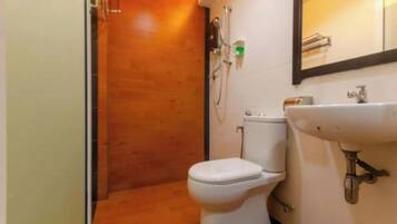 Un baño pequeño con inodoro, lavabo y ducha.