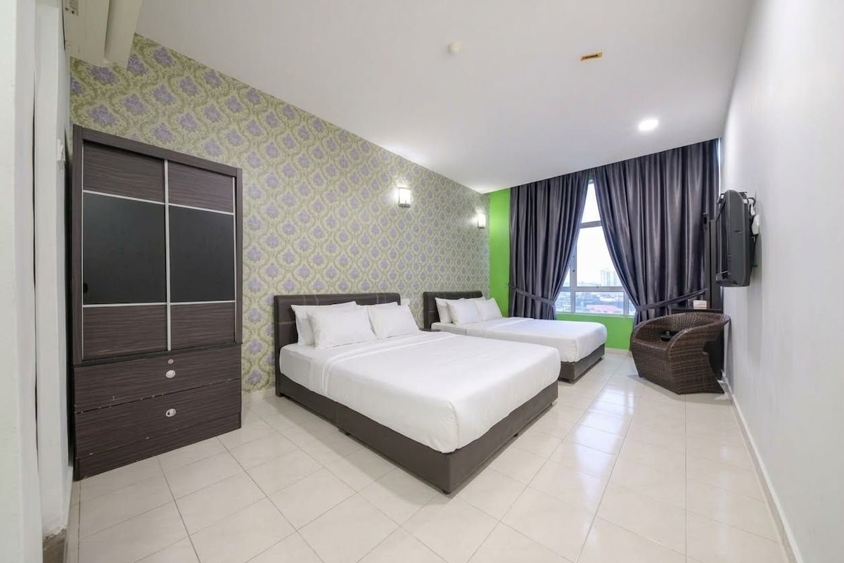 A hotel room with two beds, a wardrobe, a television, and a view of the city.