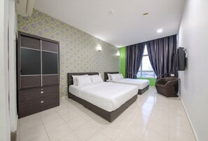 Een hotelkamer met twee bedden, een kledingkast, een televisie en uitzicht op de stad.