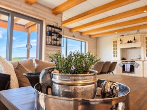 A modern kitchen with wooden beams, a dining area with a view, and a metal tray with decorative items. - Geilo ski-in/ski-out, apartment with great views (Hol)