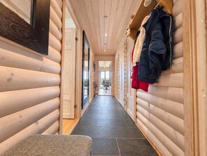 A hallway with wooden walls and a bench, leading to a room with a view. - Geilo ski-in/ski-out, apartment with great views (Hol)