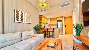 A modern living room with a sofa, a wooden coffee table, and a TV. - Sahab - Golden Hour Almamsha by Alhuty (Sharjah)