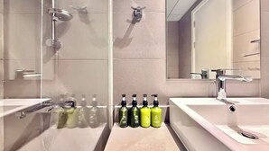 A modern bathroom with two sinks, a shower, and a large mirror. - Sahab - Golden Hour Almamsha by Alhuty (Sharjah)
