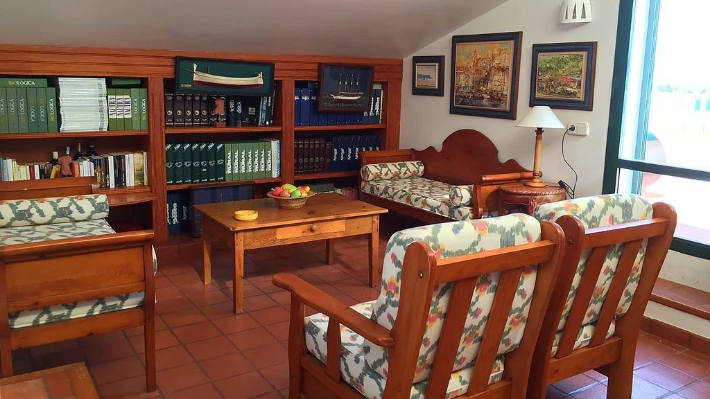 Une bibliothèque avec des étagères en bois, un canapé, une table basse et une lampe.