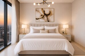 Ein modernes Schlafzimmer mit einem großen Bett, zwei Nachttischen mit Lampen, Blick auf die Stadt und einem großen abstrakten Gemälde an der Wand.