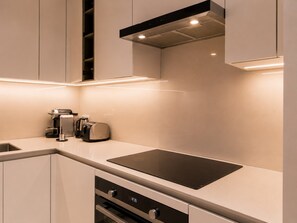 A modern kitchen with a built-in stove, a coffee maker, and a toaster. - Address Beach Resort Residences Stunning High-Floor Views Private Beach Access (دبي)