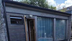 A modern building with a swimming pool, wooden deck, and large glass doors. - Peaceful 1-bedroom bed & breakfast in charming Chantraine (Chantraine)