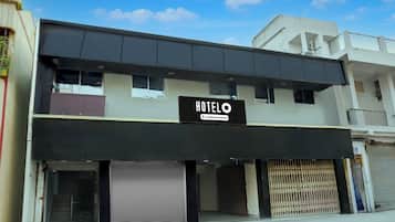 Un edificio de dos pisos con un letrero que dice 'HOTEL' y 'Company Serviced'.