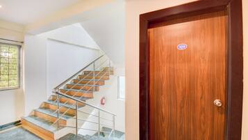 A staircase with metal railings and a wooden door with a number sticker.
