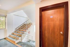 A staircase with metal railings and a wooden door with a number sticker.