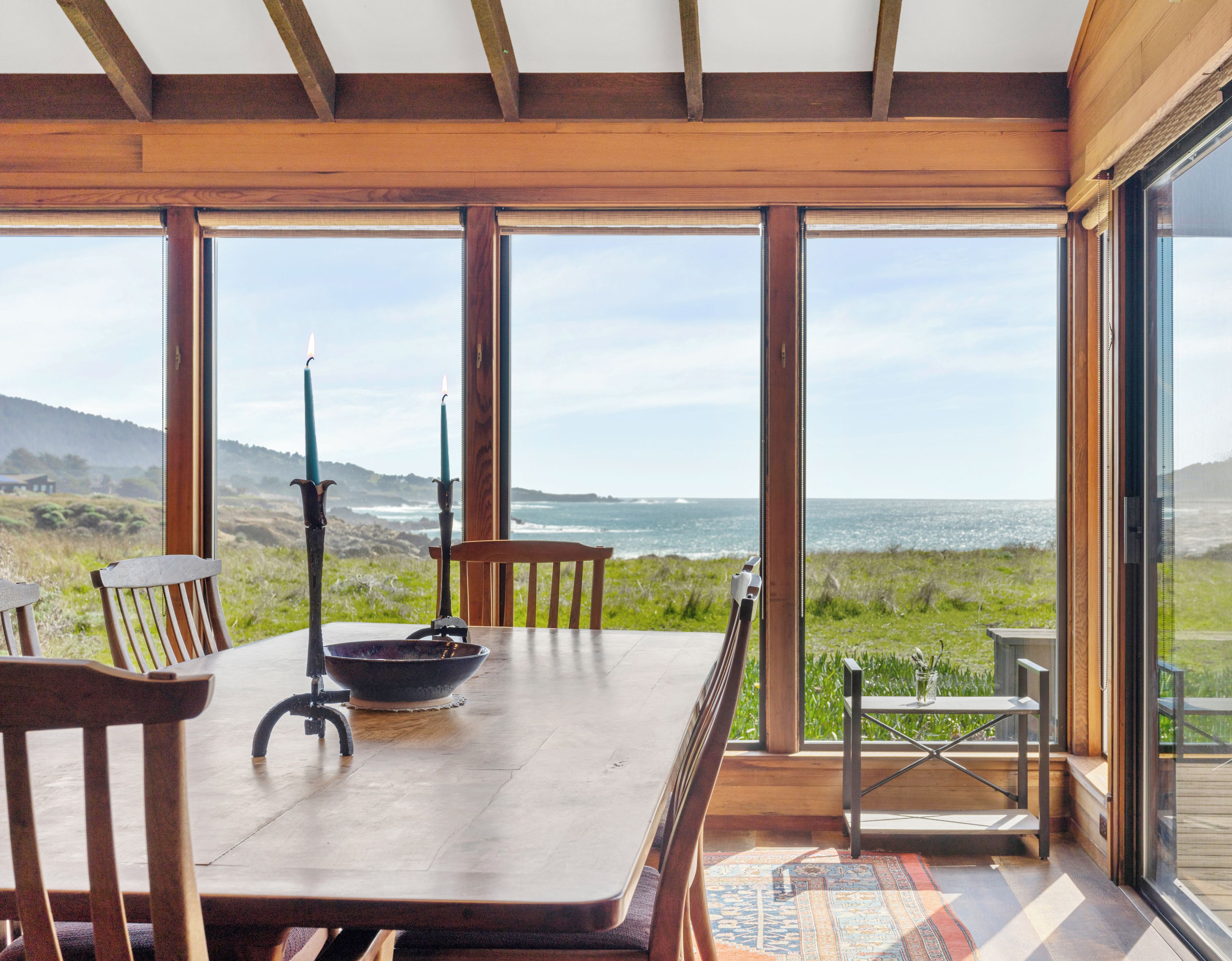 A dining area with a table, chairs, and a view of the ocean.