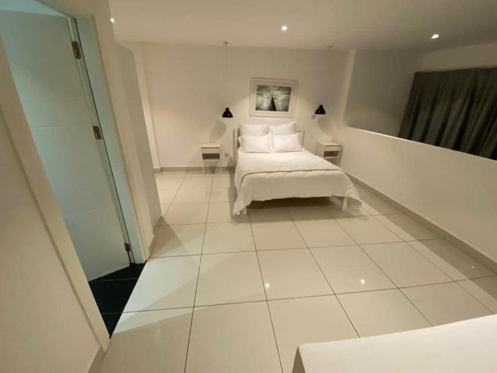 Een slaapkamer met een bed, twee nachtkastjes en een bedbank.