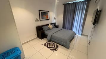 Ein Schlafzimmer mit einem Bett, einem Nachttisch, einer Lampe und einem Gemälde an der Wand.