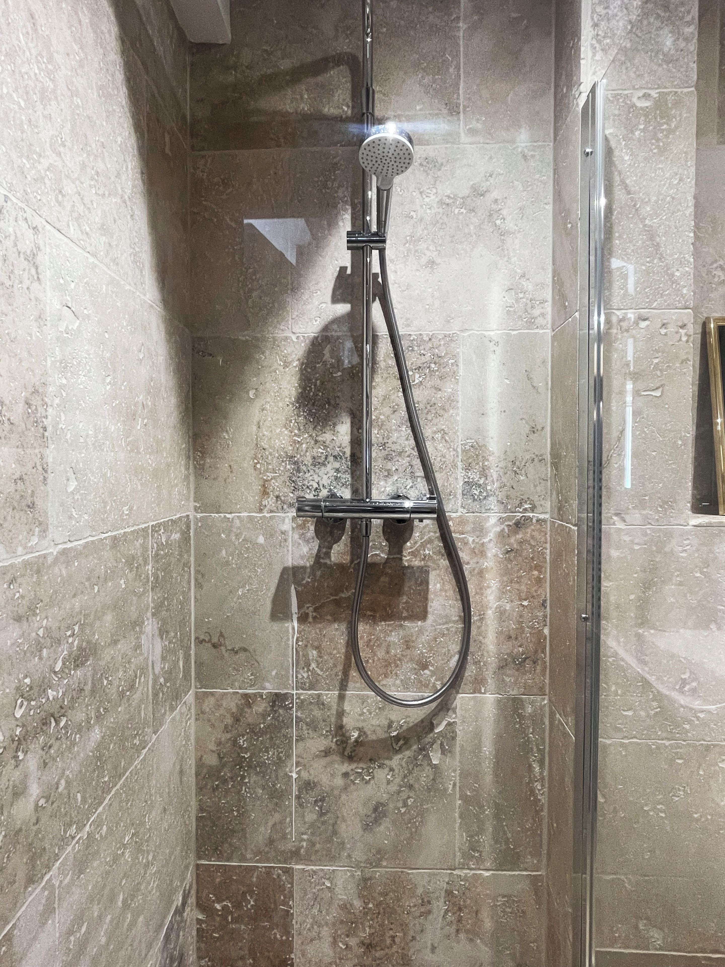 Een douche met een handdouche en een slangdouche.