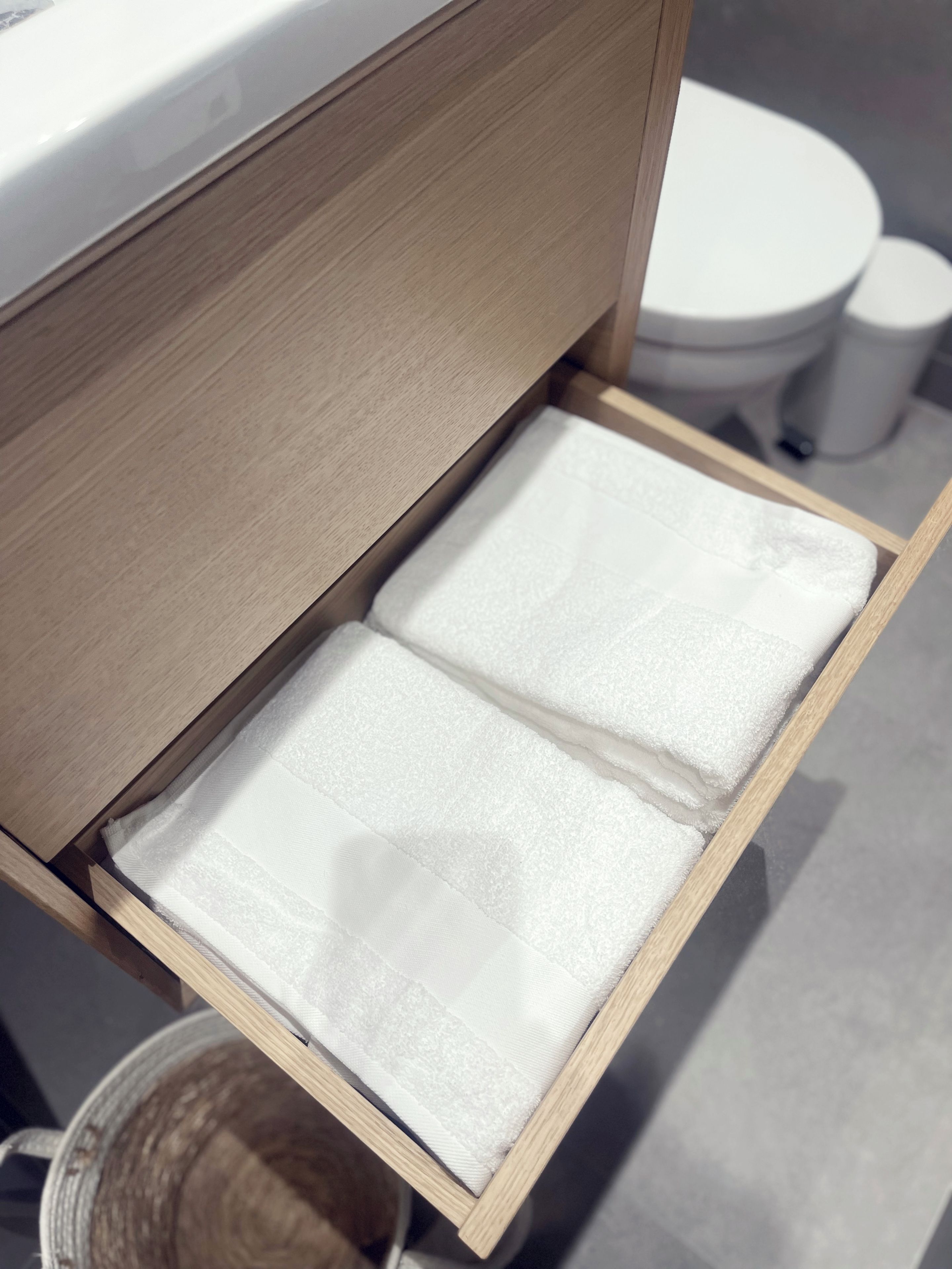 Een houten lade met een witte handdoek erin.