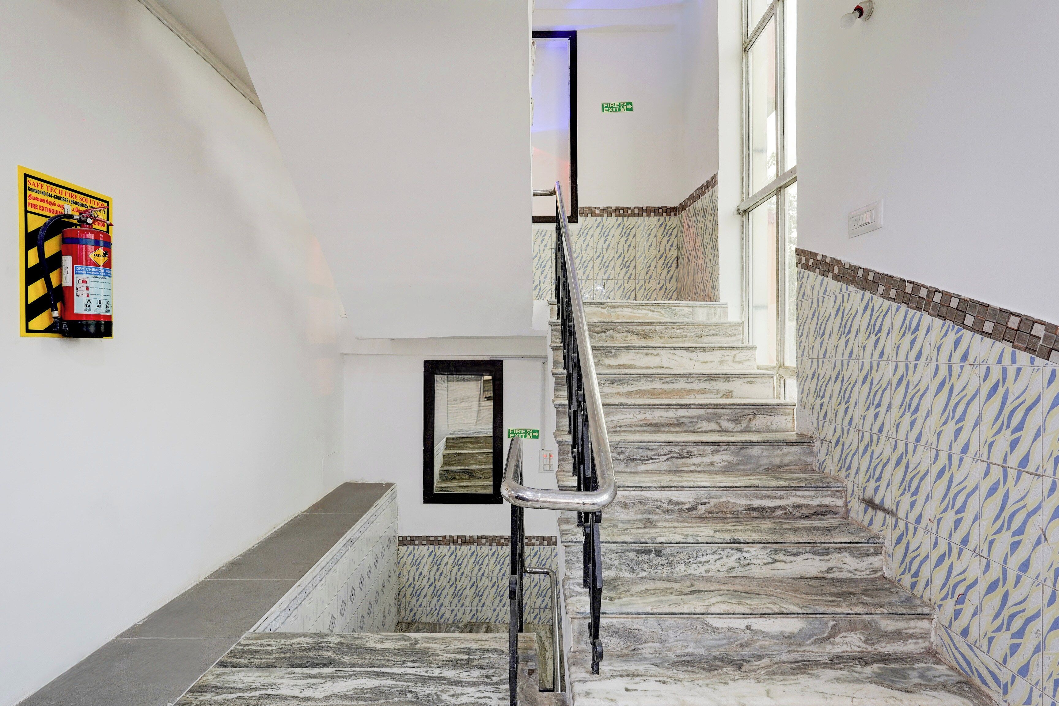 A staircase with marble steps and a handrail, leading to an upper floor.