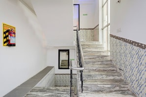 A staircase with marble steps and a handrail, leading to an upper floor.