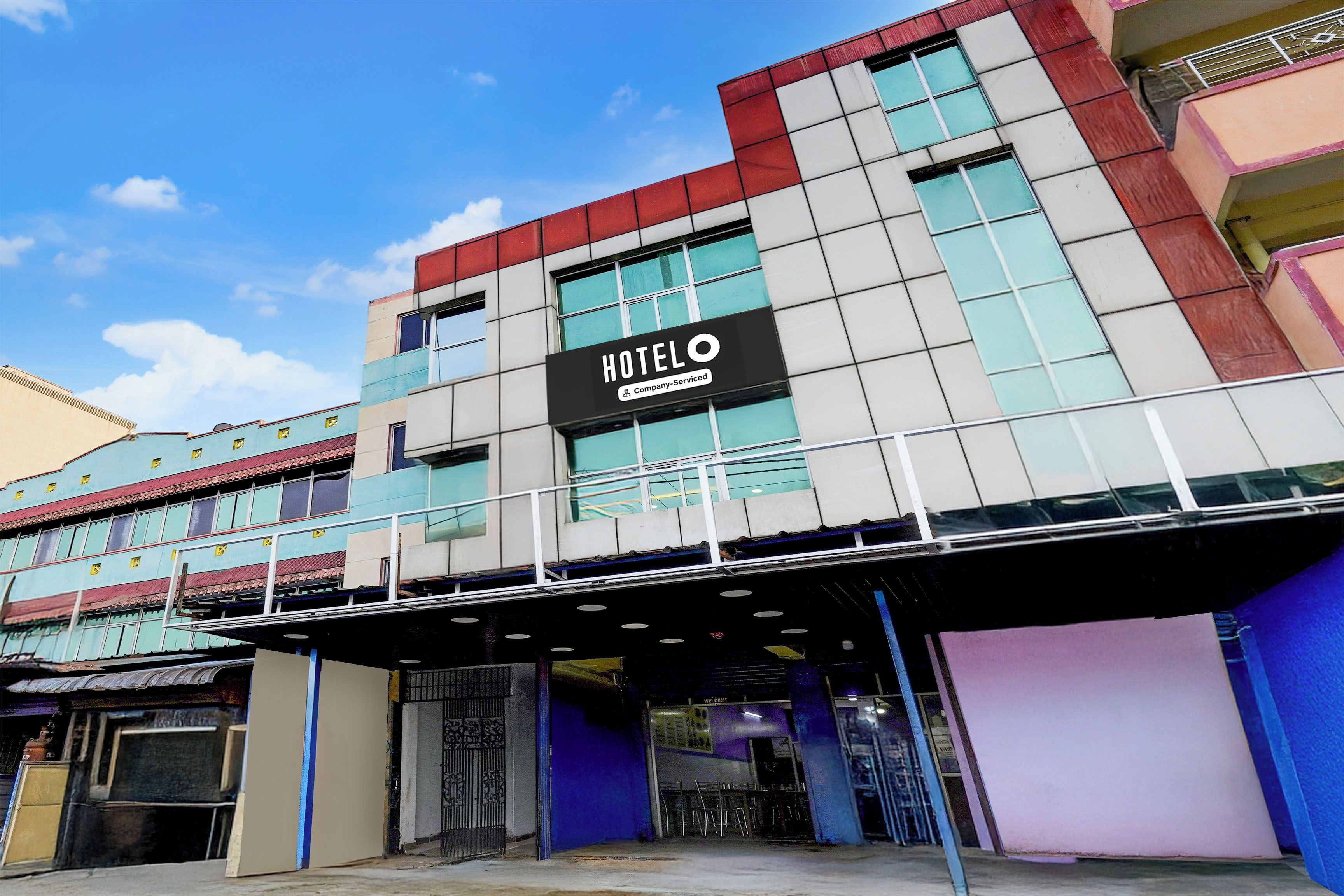 A hotel with a prominent 'HOTEL' sign, a covered entrance, and a modern architectural design.