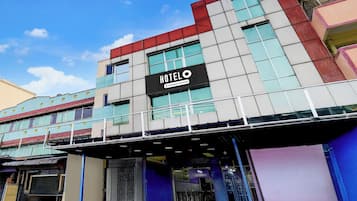 A hotel with a prominent 'HOTEL' sign, a covered entrance, and a modern architectural design.