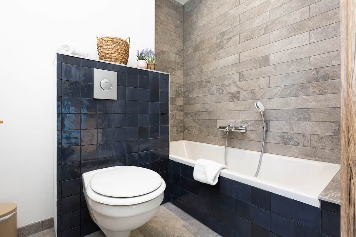 Un baño con inodoro, bañera y ducha.