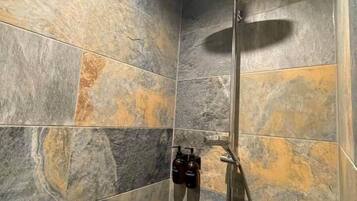 Une douche équipée d’un pommeau de douche à main, d’un autre pommeau de douche à main et d’un troisième pommeau de douche à main.