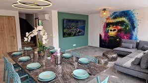 En spiseplads med et marmorbord dækket til seks personer, omgivet af teal-farvede stole.