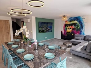 Een eethoek met een marmeren tafel voor zes personen, omringd door teal stoelen.