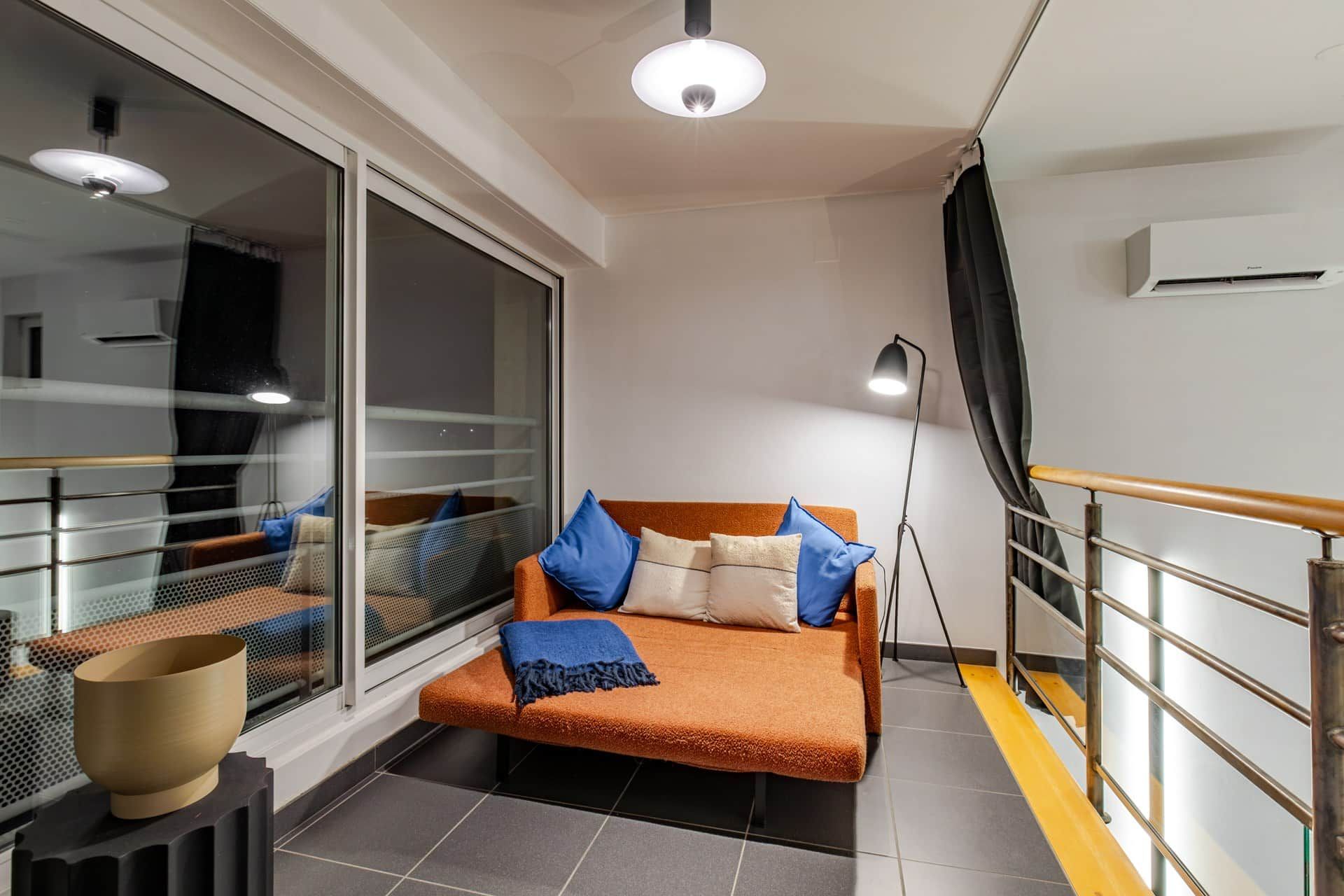 A modern room with a sofa, a small table, and a window.