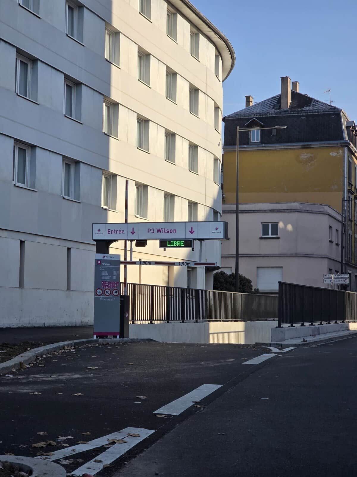 A building with a sign indicating 'Entrée' and 'P3 Wilson' with a 'LIBRE' sign below.