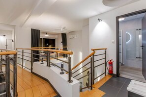 A modern interior with a staircase, a fire extinguisher, and a door leading to a bathroom. - Villa Tigre | Private Sauna/Heated Spa (Quatzenheim)