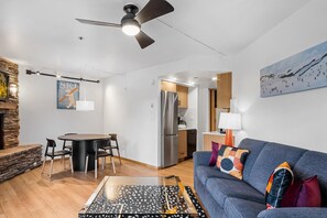 A modern living room with a sofa, a coffee table, and a dining area with chairs and a table. - Beaver Run|Ski In/Out|Cozy Chalet|Pool & Hot Tub (Breckenridge)