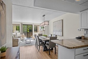 A modern kitchen with a dining area, large windows, and a view of the outdoors. - Beaver Run - Breck Blast|Ski Views|Pool&Hot Tubs (Breckenridge)