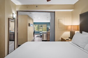A hotel room with a large bed, a desk, and a view of the kitchen and dining area. - Beaver Run-Ski-In/Out| Winter Retreat| Heated Pool (Breckenridge)