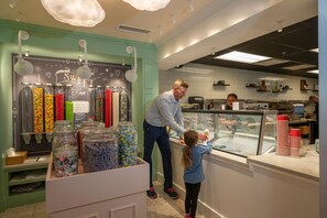 A candy store with jars of various candies and a sign offering bag filling services. - Beaver Run -Our Happy Place | Luxury Suite (Breckenridge)