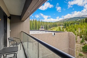 Ein Balkon mit Blick auf einen Wald und Berge.