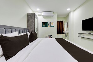 A hotel room with a large bed, a flat-screen TV, a coffee maker, and artwork on the wall. - Hotel O Krishna Riverview Vijayawada (Vijayawada)