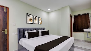 Una habitación de hotel con una cama, un baño con lavamanos y una puerta.